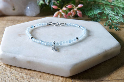 Pale blue aquamarine gemstone beaded bracelet with sterling silver leaf-shaped charm and spring ring closure.