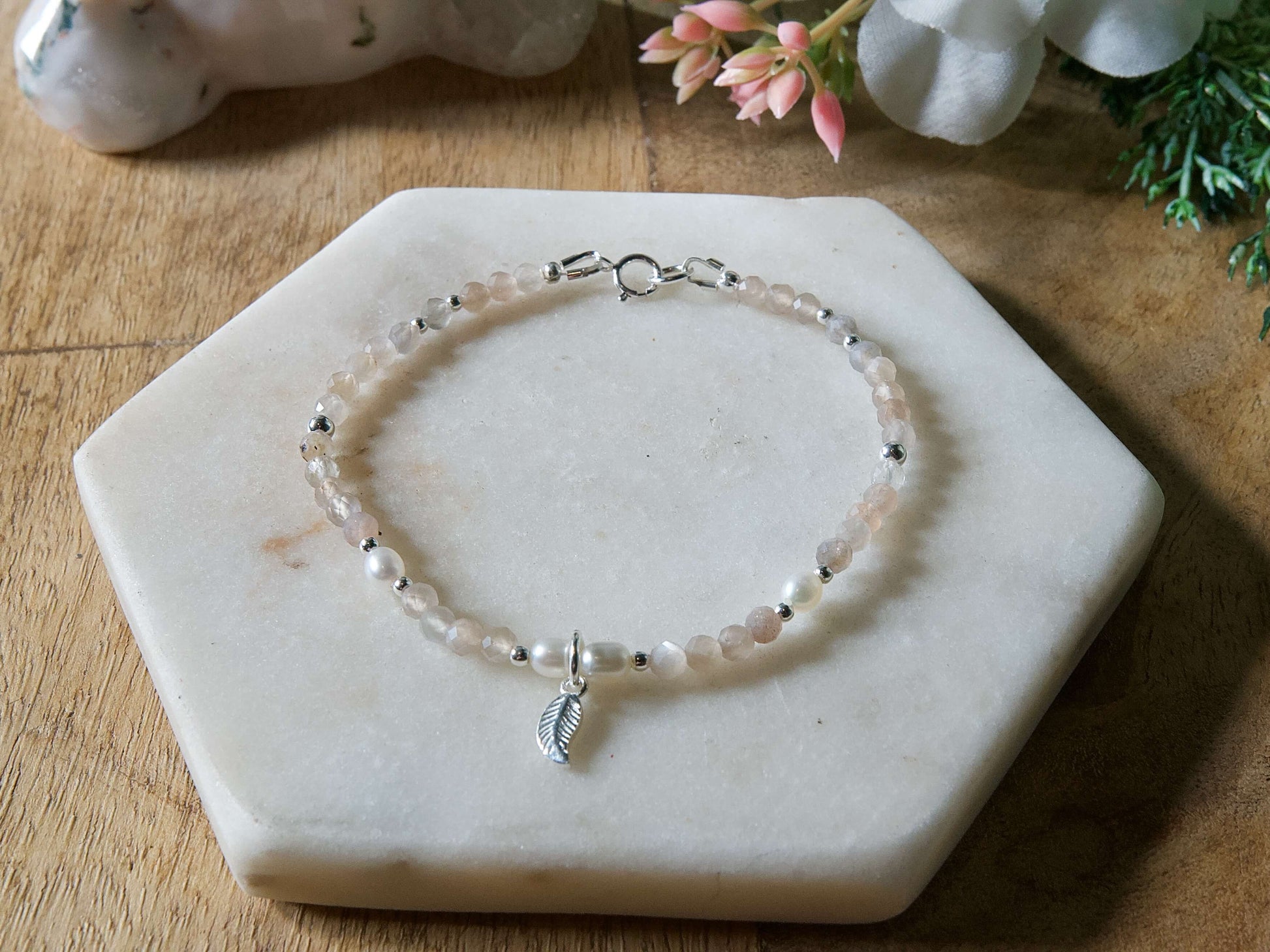 Grey moonstone and freshwater pearl gemstone beaded bracelet with sterling silver leaf-shaped charm and spring ring clasp.
