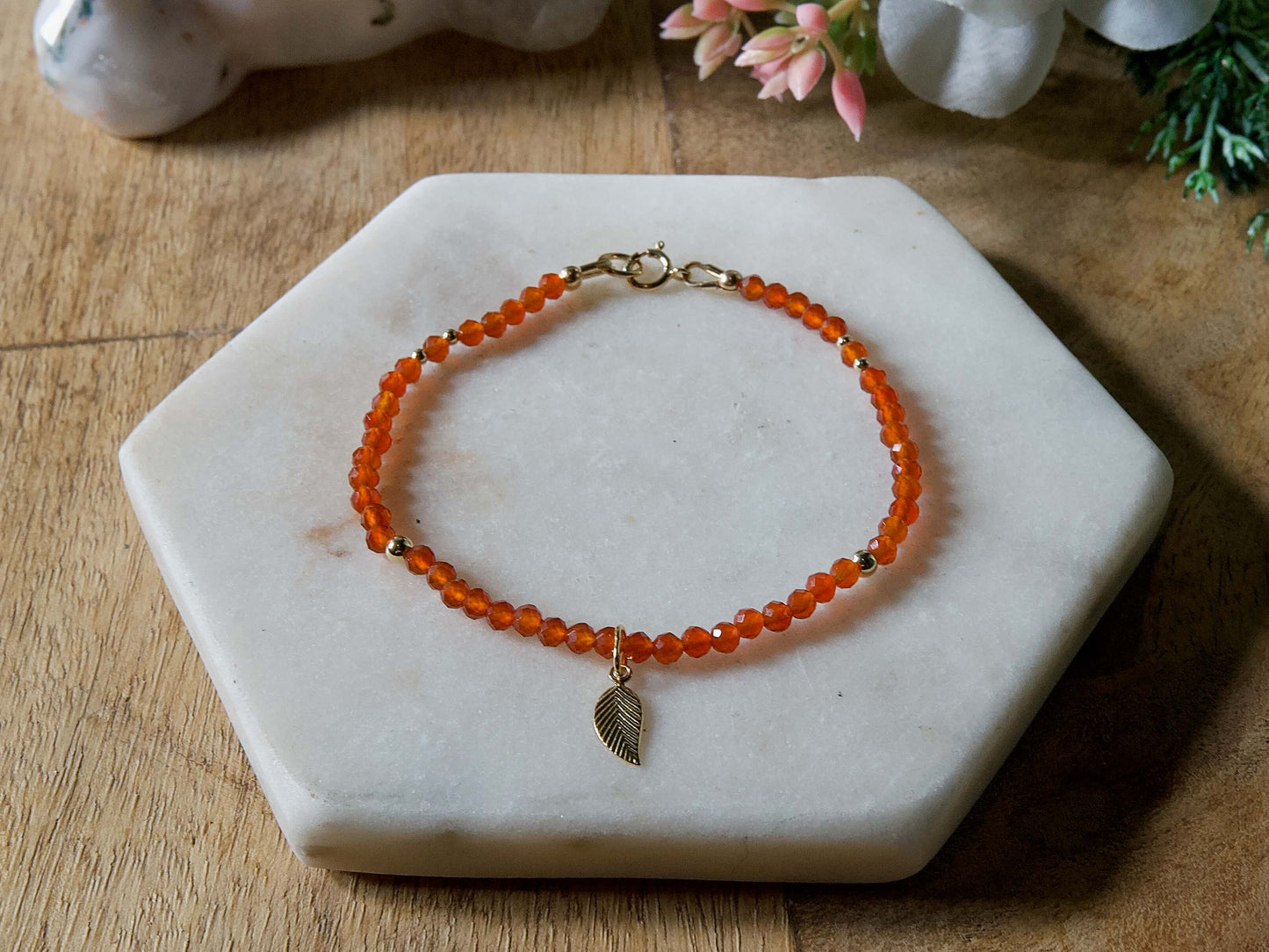 Orange carnelian gemstone beaded bracelet with 14k gold-filled leaf-shaped charm and spring ring clasp.
