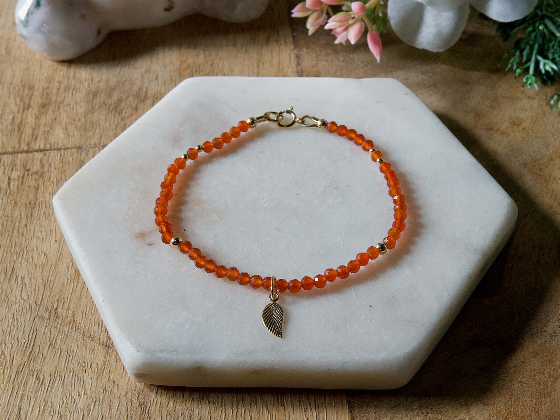 Orange carnelian gemstone beaded bracelet with 14k gold-filled leaf-shaped charm and spring ring clasp.