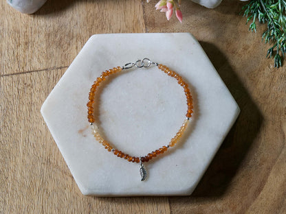 Orange and yellow Hessonite garnet gemstone beaded bracelet with sterling silver leaf-shaped charm and spring ring clasp.