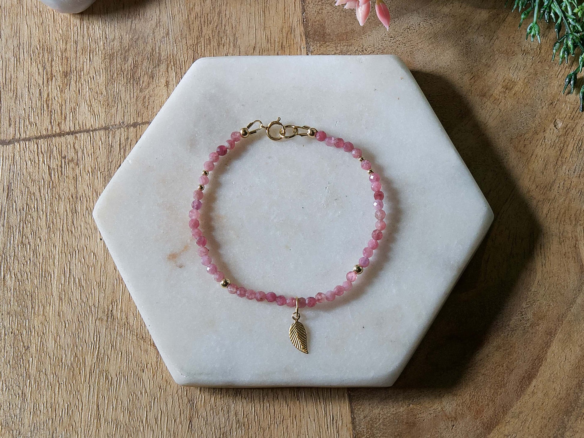 Pink tourmaline gemstone beaded bracelet with 14k gold-filled leaf-shaped charm and spring ring closure.