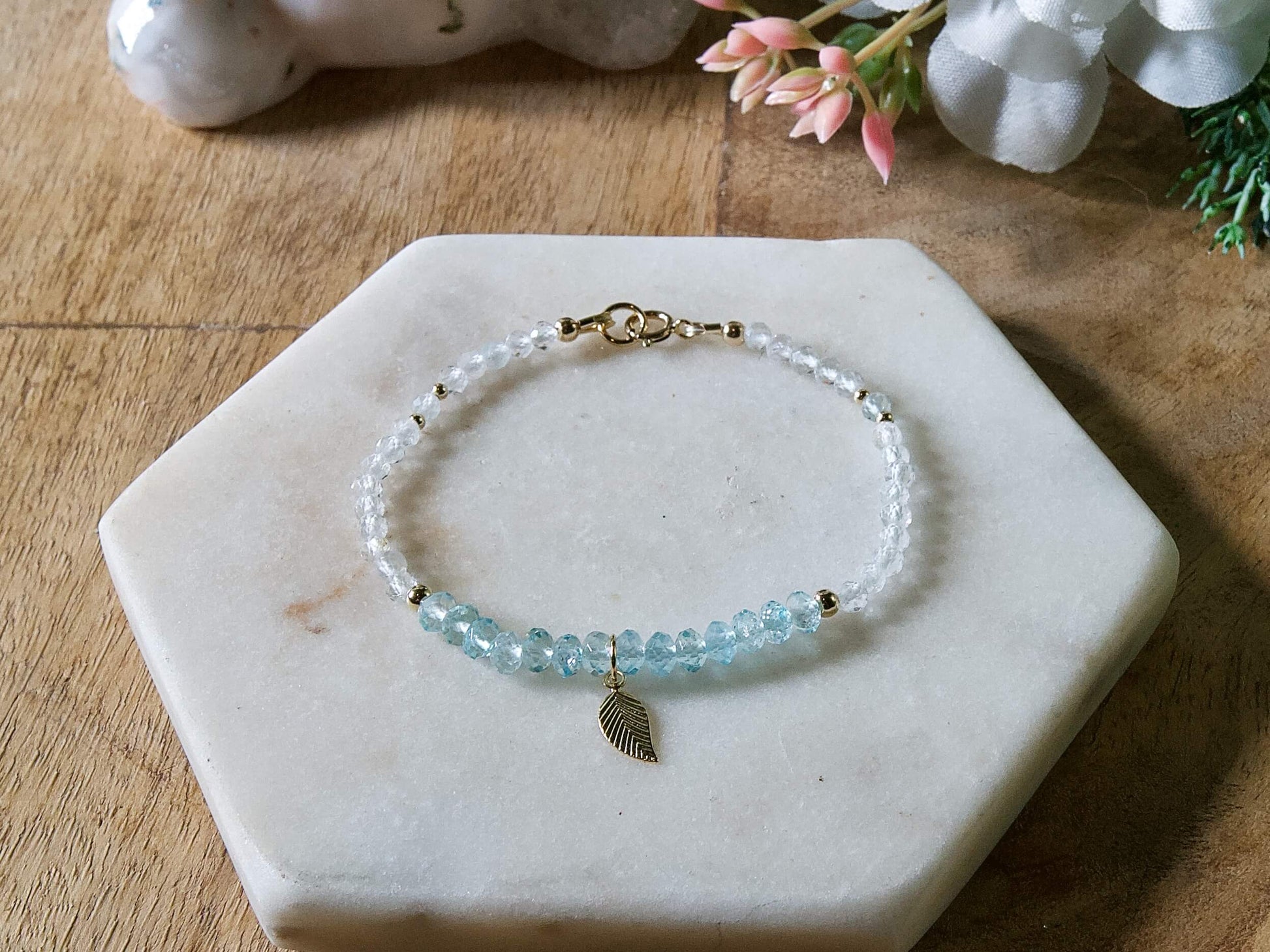Blue and white topaz gemstone beaded bracelet with 14k gold-filled leaf-shaped charm and spring ring clasp.