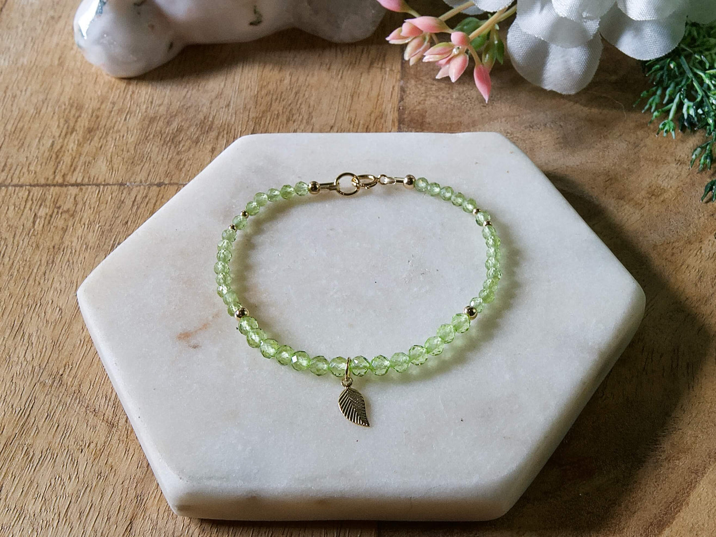 Green peridot gemstone beaded bracelet with 14k gold-filled leaf-shaped charm and spring ring closure.