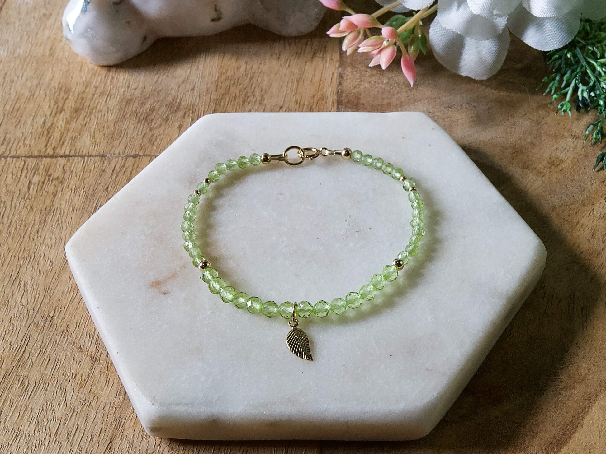 Green peridot gemstone beaded bracelet with 14k gold-filled leaf-shaped charm and spring ring closure.