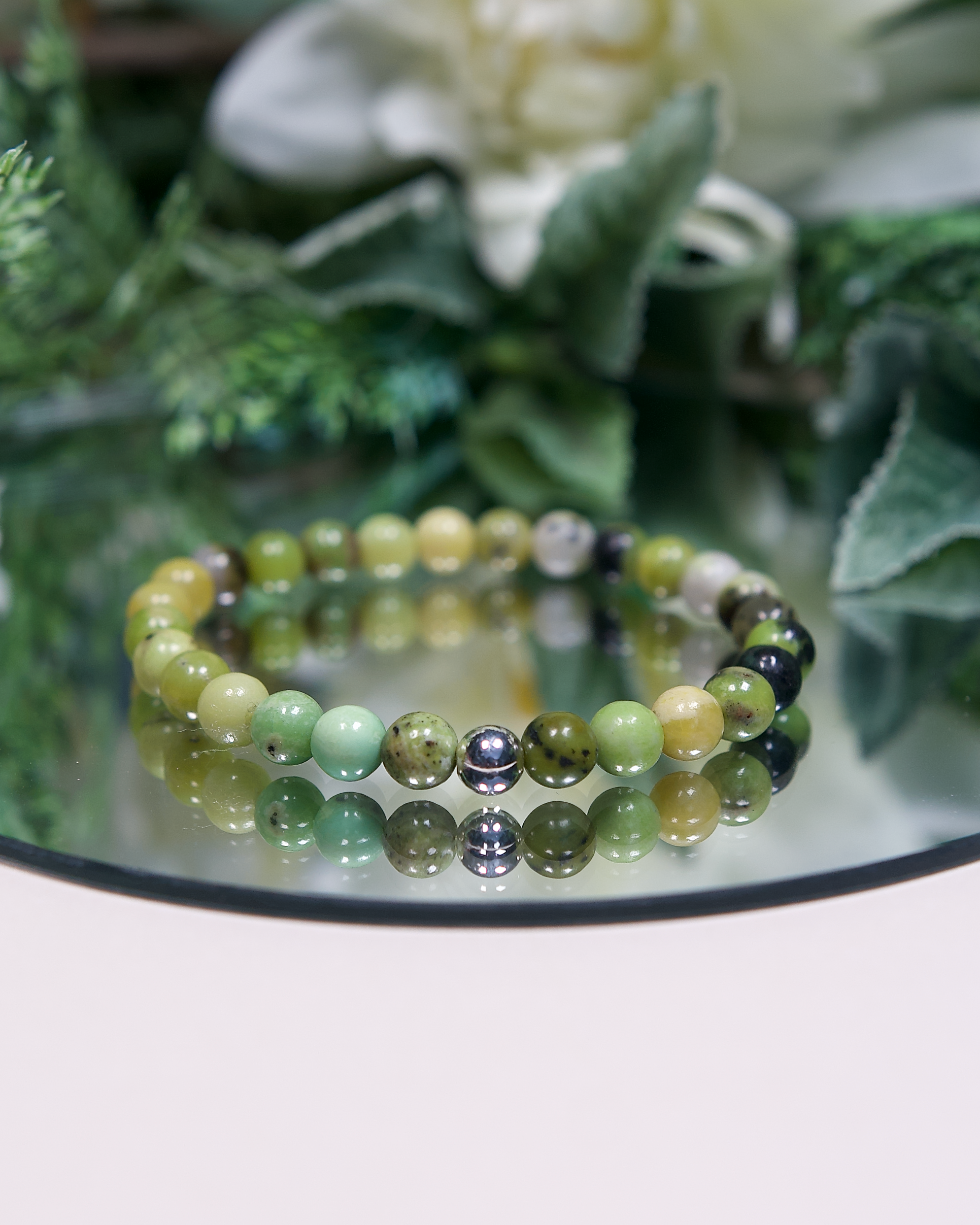 Close up of green chrysoprase beaded bracelet with sterling silver accent bead.