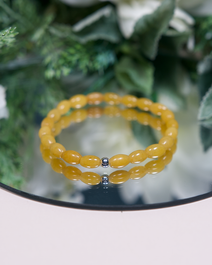 Yellow Aventurine barrel-shaped beaded bracelet with sterling silver accent bead on mirrored plate