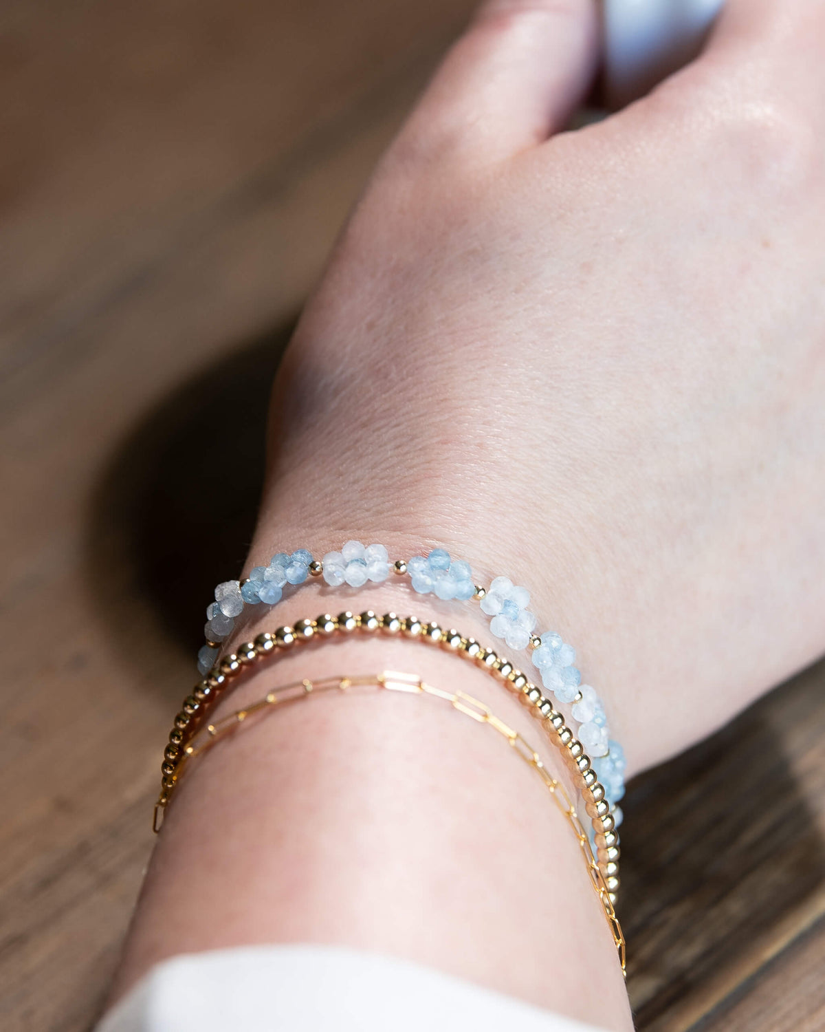 Pale and sky blue aquamarine beaded daisy chain bracelet with 14k gold-filled accents and spring ring clasp.