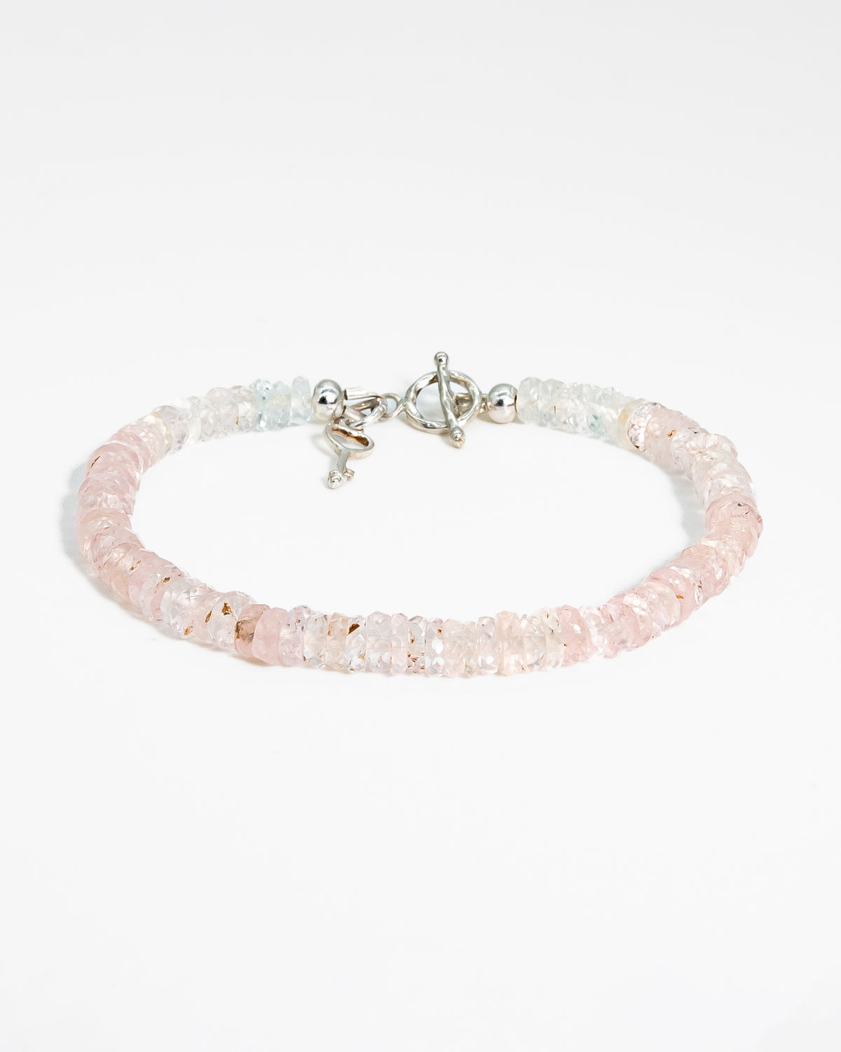 Pale pink, high clarity faceted morganite beaded bracelet with sterling silver key-shaped charm and toggle closure