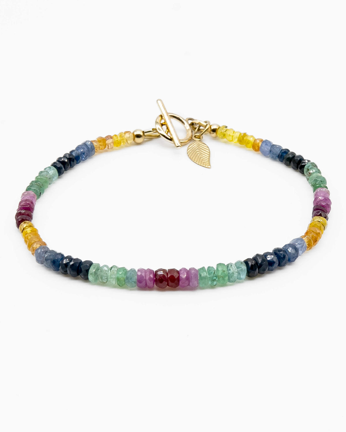 Yellow, blue, green, pink, and red sapphire beaded gemstone bracelet with 14k gold-filled toggle clasp and leaf-shaped charm.