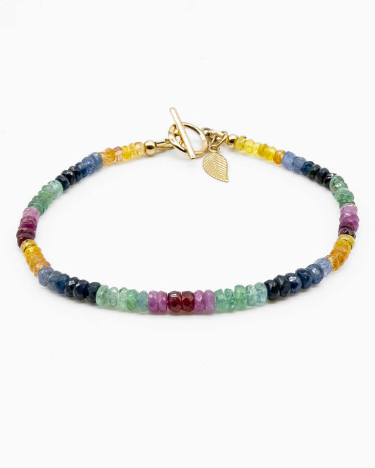 Yellow, blue, green, pink, and red sapphire beaded gemstone bracelet with 14k gold-filled toggle clasp and leaf-shaped charm.