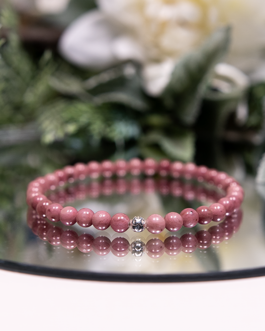 Pink Rhodonite bracelet with rosy pink round beads and hammered sterling silver accent bead on mirrored plate