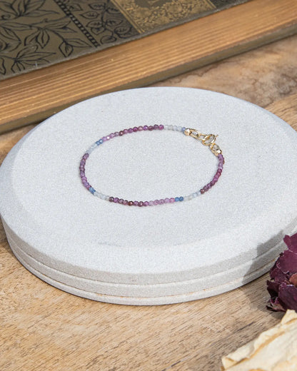 Dainty pink, blue, and white ruby sapphire beaded bracelet with 14k gold-fill spring ring clasp on light background
