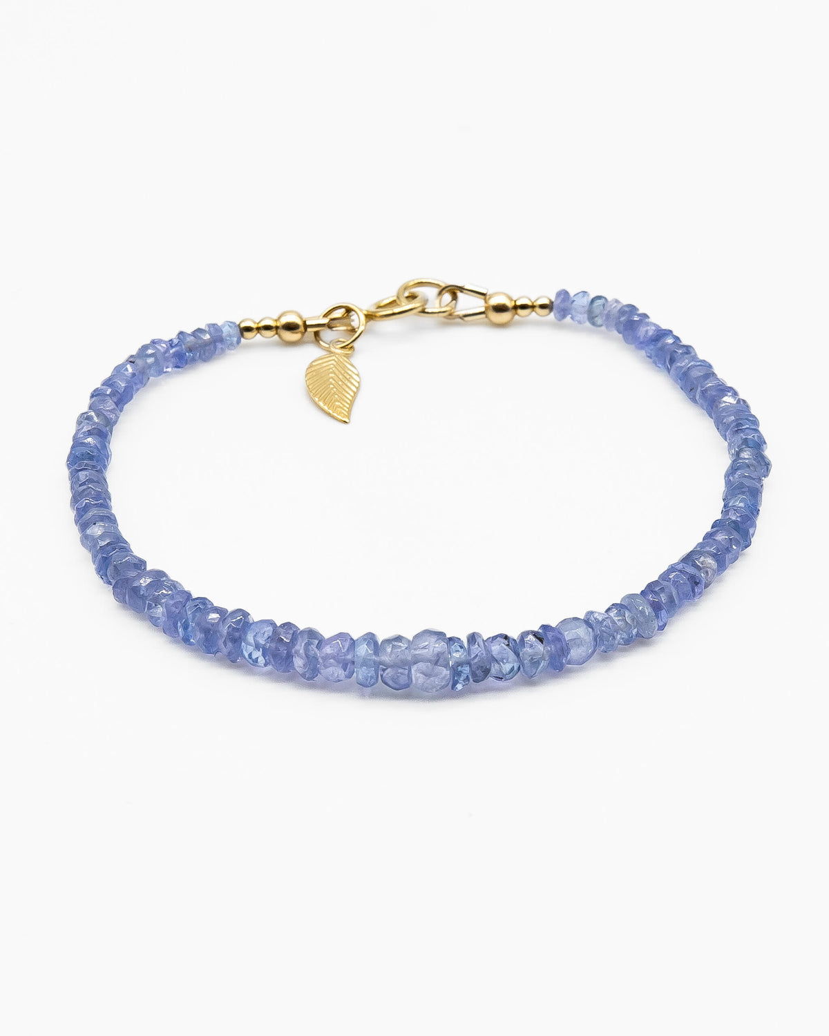 Cornflower blue faceted Tanzanite beaded bracelet in graduated size with 14k gold-filled leaf-shaped charm and spring ring clasp