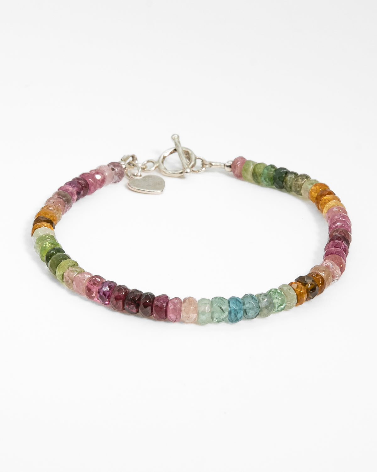 Pink, blue, green, yellow, and brown faceted tourmaline bracelet with sterling silver heart-shaped charm and toggle clasp